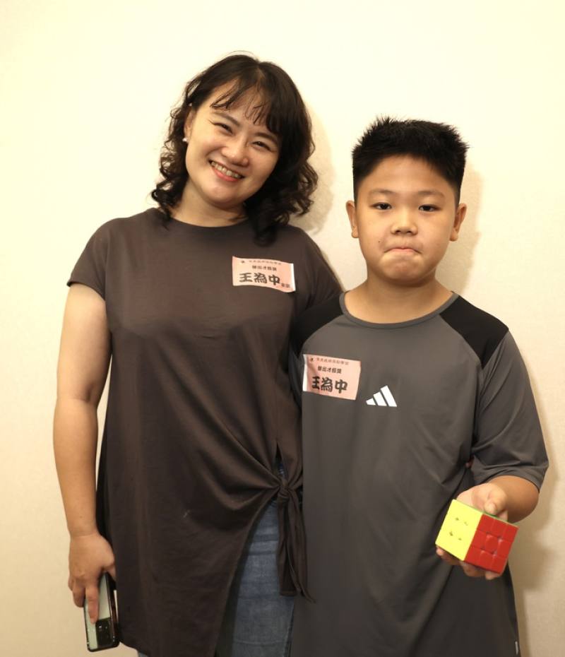 11歲王小弟（右）曾因罕見粒線體疾病MELAS症候群夢碎，黯然退出最愛的足球場，改用雙手轉出覺醒新人生，也讓一家人重新翻轉愛的定義，15日在媽媽陪同下，出席罕見疾病獎學金頒獎典禮