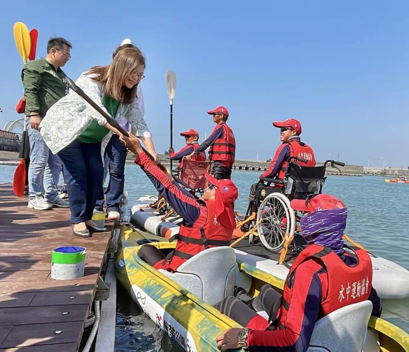 海洋委員會與水中運動協會16日在高雄彌陀漁港海岸光廊舉辦「勇敢逐浪、無礙前行」無障礙親海體驗活動，由海委會主委管碧玲（前左）主持，並在全台首座無障礙入水輔助平台進行遞槳啟航儀式。（海洋委員會提供）