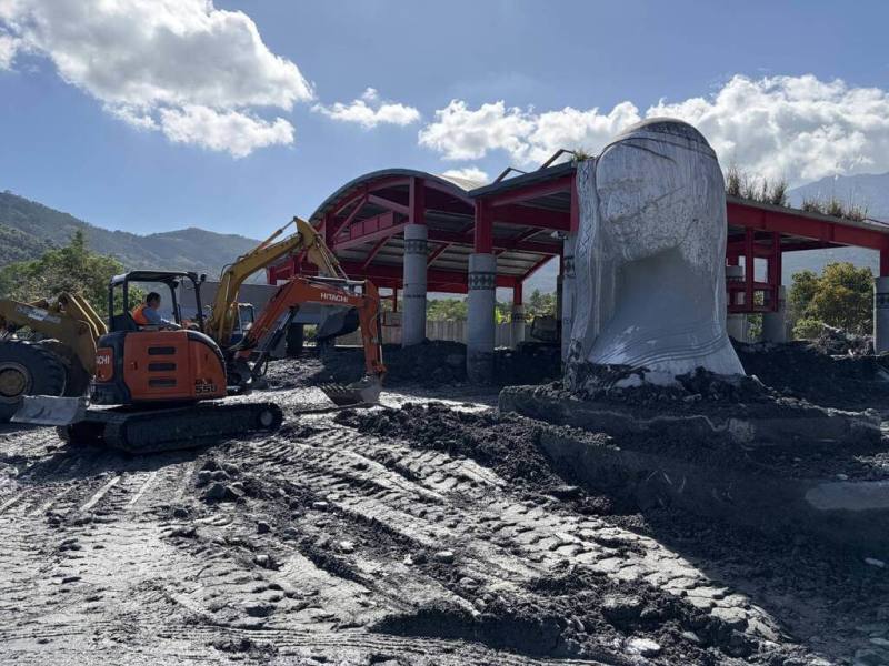颱風鳳凰帶來風雨造成馬太鞍溪堰塞湖溢流，花蓮萬榮鄉明利部落的精神象徵「紋面阿嬤」雕像遭土石淹沒；花蓮縣政府團隊動員重型機具趕工清淤，讓雕像重現。雖然周遭環境仍是一片狼藉，但機具仍持續清理，期待儘快還給部落一個乾淨、安心生活空間。（花蓮縣政府提供）
