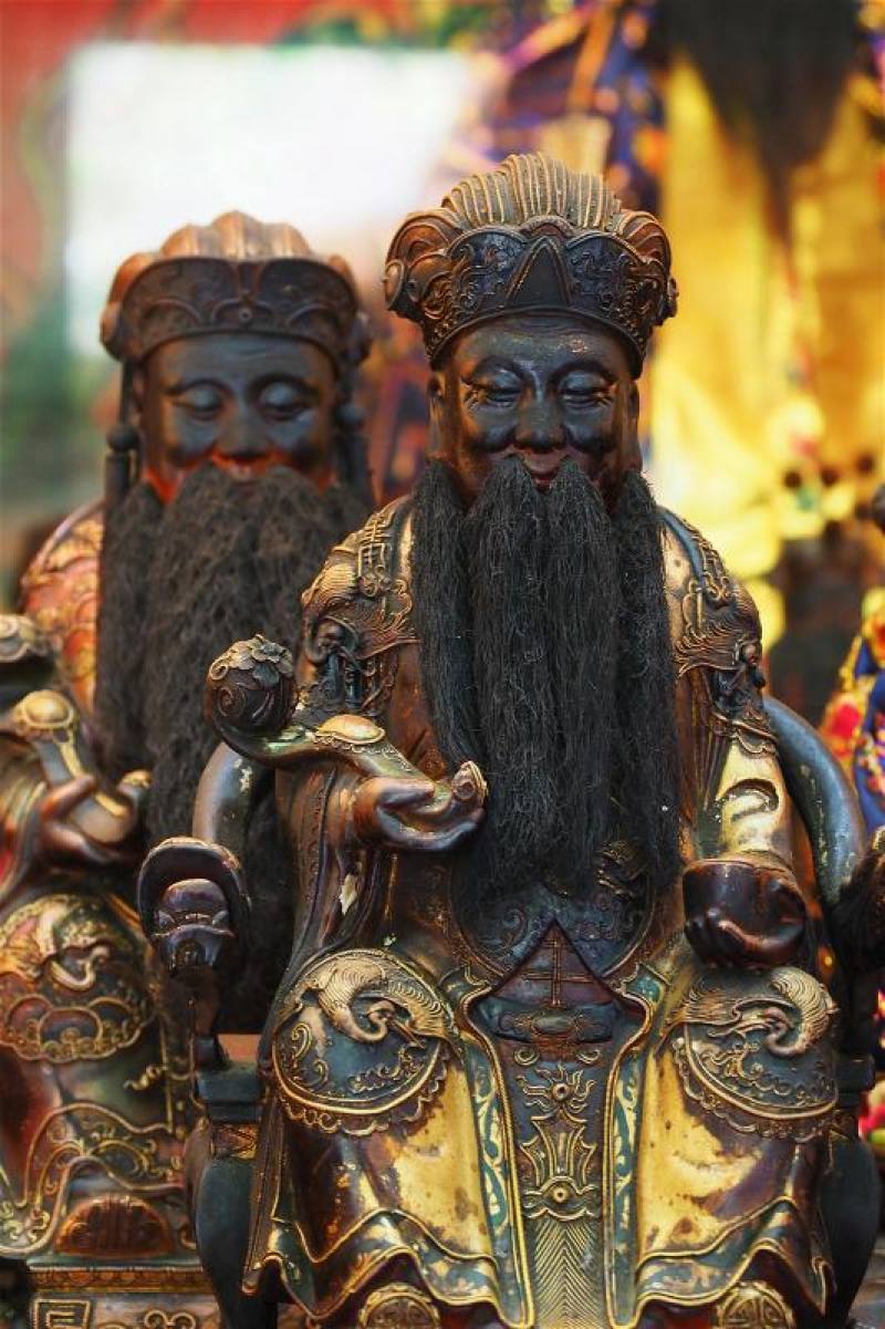 市街的土地公手持元寶，象徵財富