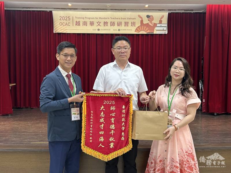 清平民立華文學校校長廖子權（圖左）及新慈念華語中心校長盧佩攸（圖右）致贈錦旗及紀念品，師大進修推廣學院院長胡衍南（圖中）代表接受