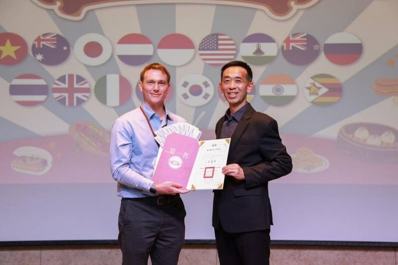 由國立國父紀念館主辦的「2025年外籍學生華語文演講比賽」25日結果揭曉，館長王蘭生（右）頒發獎狀與獎金給冠軍得主、來自美國的溫柯橋（左）。（國父紀念館提供）