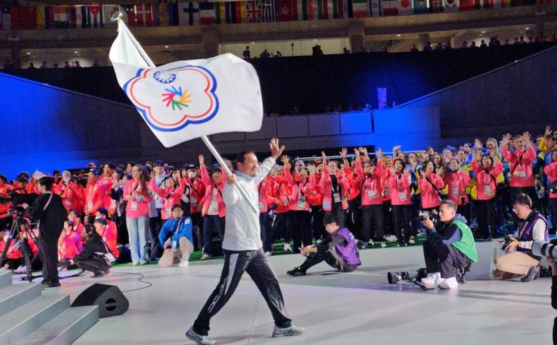 安慶隆教練在全場熱烈歡迎中，以排序T序位掌旗進場