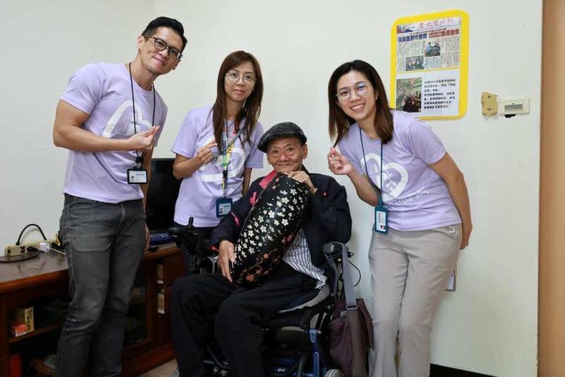 漆畫師江添昌（右2）在光復洪災中，家園被洪水吞沒，生命一度懸於一線，獲救後幸有門諾醫院長照部協助，讓他回到自己生活節奏。（門諾醫院提供）