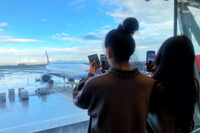 桃園國際機場第3航廈北登機廊廳1日試營運，機場公司表示，試營運首日安排中華CI130、長榮BR116及星宇JX741共3家國籍航空約968名旅客，飛往日本札幌及泰國曼谷，候機旅客利用等待時間在大片玻璃帷幕前拍照。