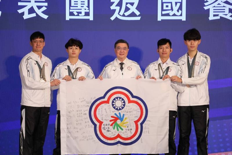 2025年東京第25屆達福林匹克運動會返國餐會，由桌球男子團體銀牌選手楊榮宗(左1)、王顗翔(左2)、郭岳東(右2)、盧仕杰(右1)致贈簽名團旗予行政院卓榮泰院長(中)