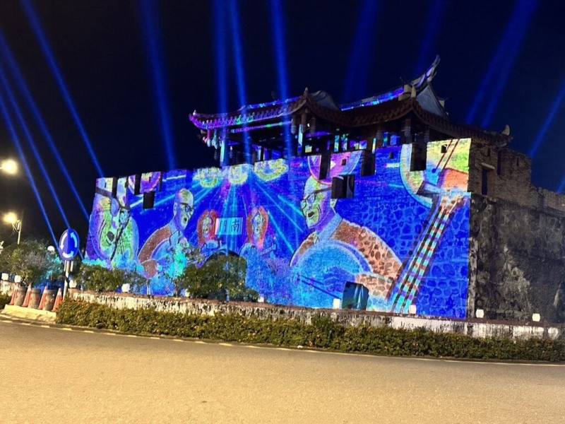 屏東縣政府以光影藝術點亮古城歷史風華，南門在夜晚華麗變身為時光舞台，跨域音樂搭配大型光雕投影，訴說恆春半島歷史軌跡。（屏東縣政府文化處提供）