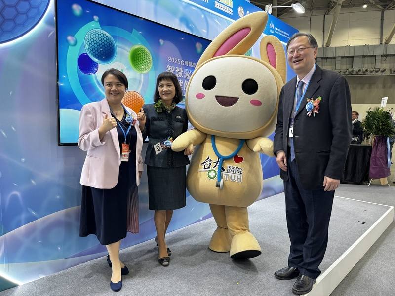 2025台灣醫療科技展4日起連續4天在台北南港展覽館登場，台大醫院也參展，院長余忠仁（右）等人與醫院吉祥物「醫寶」在展區開心合影。