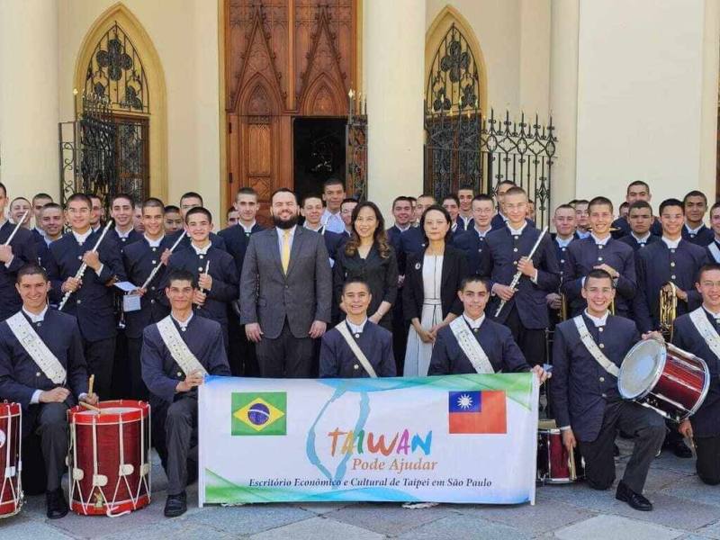 駐聖保羅台北經濟文化辦事處5日於天主教「巴西福音使者協會」聖保羅總部舉行樂器捐贈儀式，處長朱怡靜（第2排正中）、聖保羅州議會友台陣線主席狄尼茲（第2排左4）等人和巴西福音使者協會附屬高中管弦樂團合影。（駐聖保羅辦事處提供）