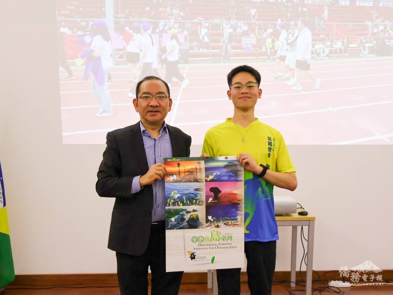 聖保羅文教中心主任尤正才（左）贈送僑委會2026年月曆，由學員張修豪（右）代表接受