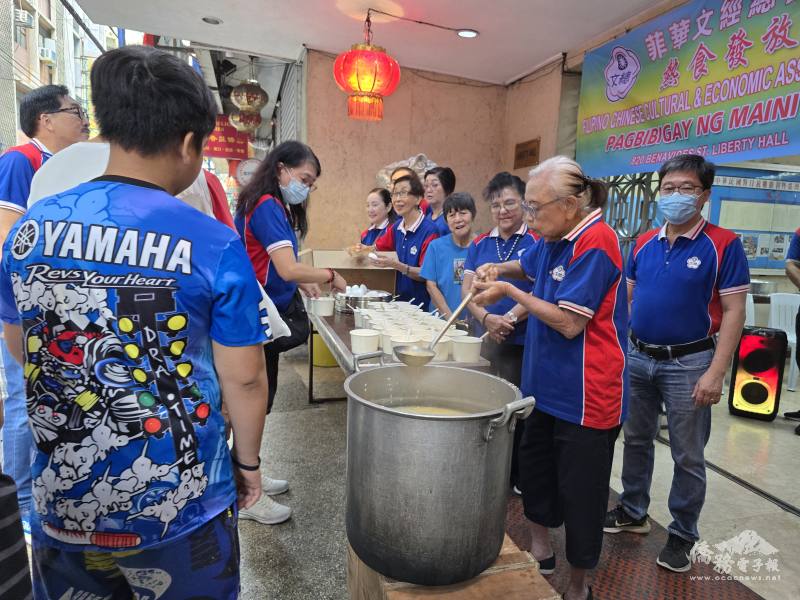 菲華文經總會委員們分送碎肉粥、水煮蛋、麵包及餅乾予排隊民眾。