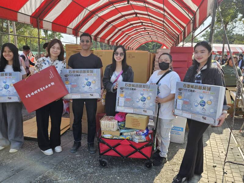 雲林家扶中心7日舉辦「被」愛包圍歲末園遊會，虎尾科技大學公共事務組長張逸品（左2）帶著學校的國際生到會場協助搬運物資，場面溫馨。