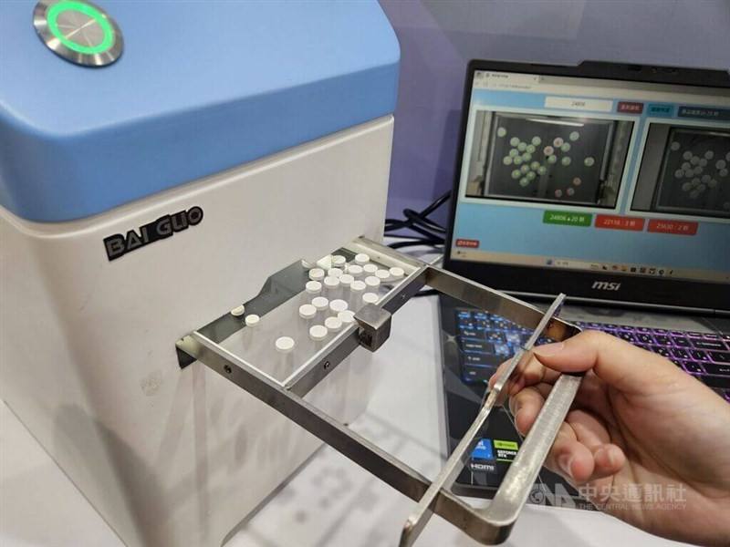 Medicine pills are processed through a machine in this CNA file photo