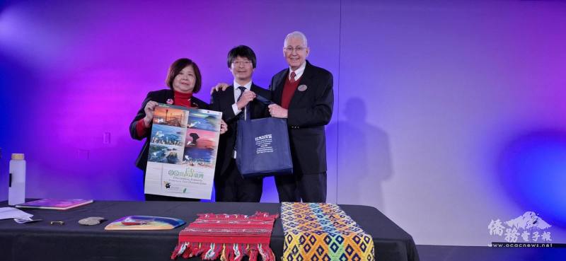 密西根人文協會會長暨大底特律區臺灣商會會長楊逸鴻(左)、芝加哥文教中心主任蔡季穎(中)，贈送2026年僑委會「僑見寶島臺灣」月曆以及臺灣文化紀念品給尹因印(右)