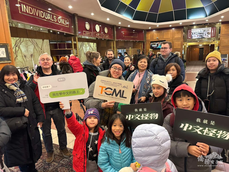 參與者在展館入口高舉學習中文與僑校標語，展現積極參與華語教育與與臺灣文化交流的熱情。