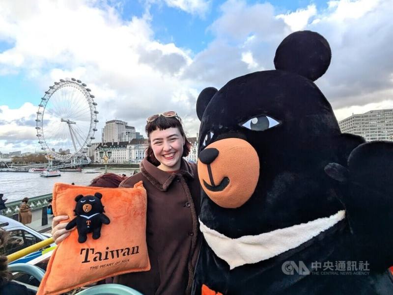 英國插畫家漢娜（左）為台灣設計的觀光巴士全車身廣告12月在倫敦上路，她10日與觀光署吉祥物「喔熊」一同乘車體驗。漢娜告訴中央社，希望透過廣告設計傳達台灣的溫暖
