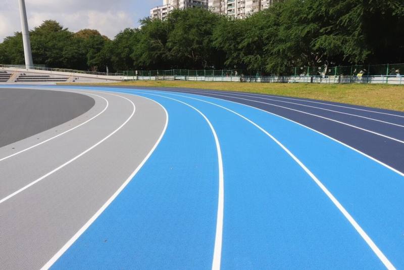 新北市新莊體育園區田徑場跑道已整修完成，全新3色分道跑道巧妙結合機能與美感，淺灰色為快速道、淺藍色為慢速道、深藍色為緩速道，讓跑者能依自身速度分流。（新北市體育局提供）