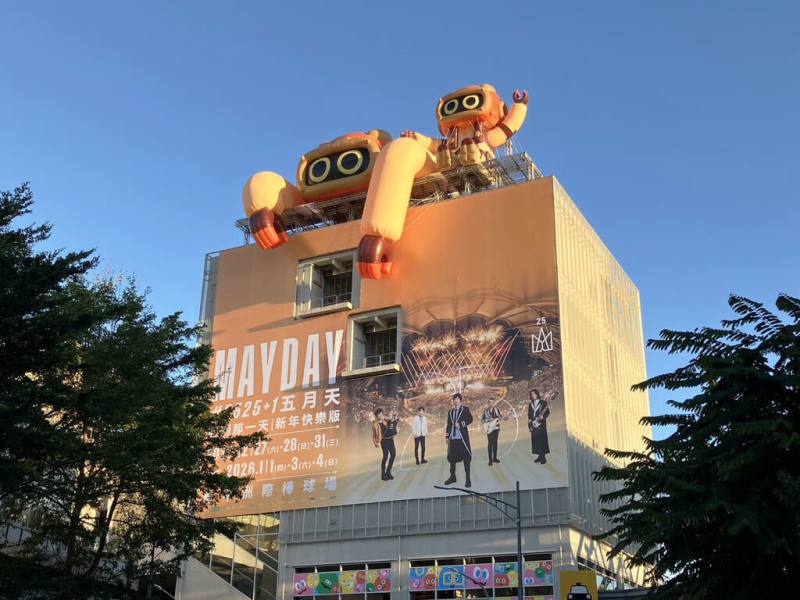 五月天樂團今年底將在台中開唱，台中捷運規劃行銷活動，綠線松竹站外牆換上巨幅五月天演唱會主視覺帆布，窗貼則以象徵五名團員的五色表情球打造繽紛氛圍，吉祥物「菜頭粿」更裝飾在車站頂樓，相當吸睛。（台中捷運提供）