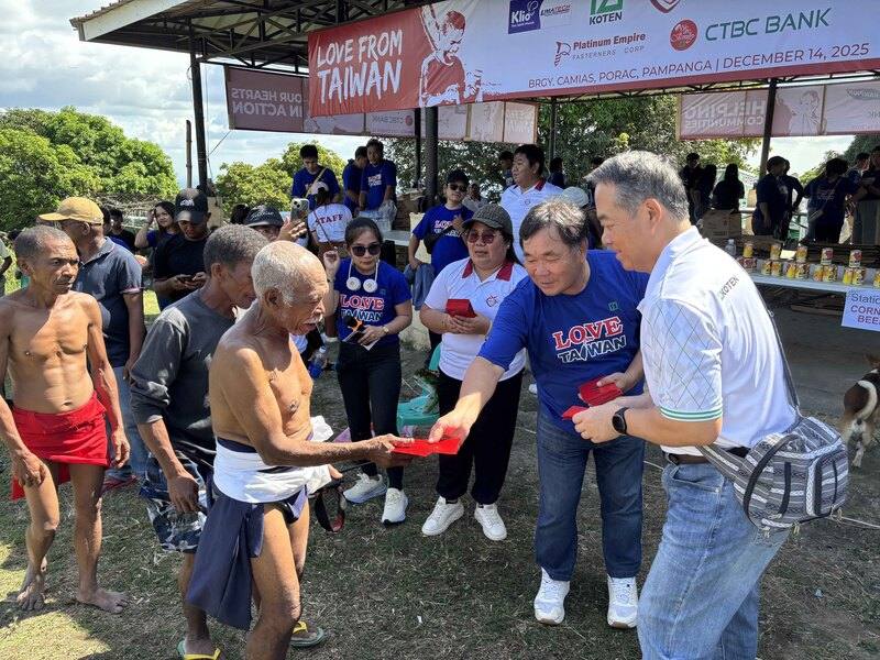 耶誕節將屆，旅菲台商企業KOTEN公司成立的慈善基金會，14日遠赴呂宋島中部山區賑濟原住民。圖為僑務諮詢委員丁金煌（前右2）分發耶誕節紅包