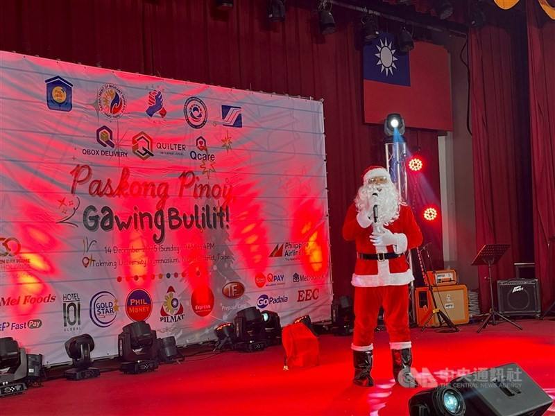 Dressed as Santa Claus, Filipino singer Cristofer de Jesus performs on stage at a Christmas event held by the Manila Economic and Cultural Office (MECO) in Taipei on Sunday. CNA photo Dec. 14, 2025