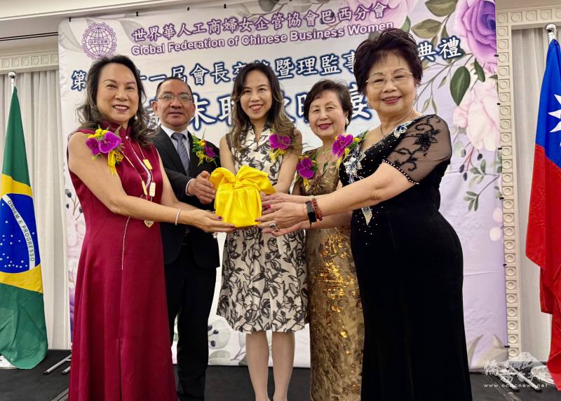 駐聖保羅辦事處處長朱怡靜（中）、聖保羅文教中心主任尤正才（左二）、世華國際諮詢委員洪呂麗月（右二）的監交下，第10屆會長范德宜（左一）把印信交給第11屆會長林月嬌（右一）