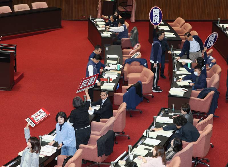 Taiwanese lawmakers hold up “agree” and “disagree” cards during a vote on extending the current Legislative Yuan session until Jan. 31, 2026, at the Legislative Yuan in Taipei on Friday. CNA photo Dec. 19, 2025