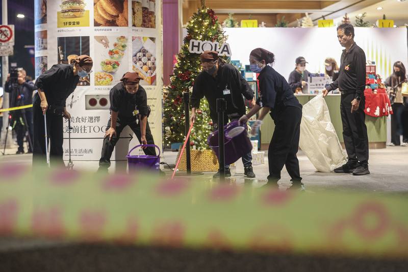 Eslite Nanxi staff members tidy up the area outside the bookstore-shopping complex near Taipei Metro’s Zhongshan Station after a random attack on Friday night. CNA photo Dec. 19, 2025
