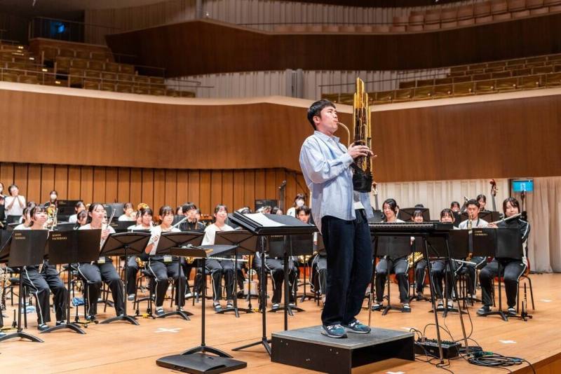 A Root同根生團長楊智博（前）21日前往高雄衛武營，與日本京都橘高校吹奏樂部相見歡，並嘗試以笙與「橘色惡魔」共演曲目。（文總提供）