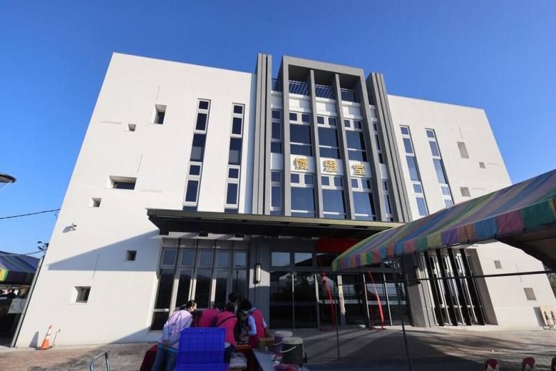 南投縣中寮鄉公所新建第10公墓納骨塔「懷恩堂」，外觀簡潔莊嚴，採光、通風良好，加強環境綠化，跳脫納骨塔傳統森嚴氣氛，乳白色系外牆搭配正面落地窗設計。（南投縣政府提供）