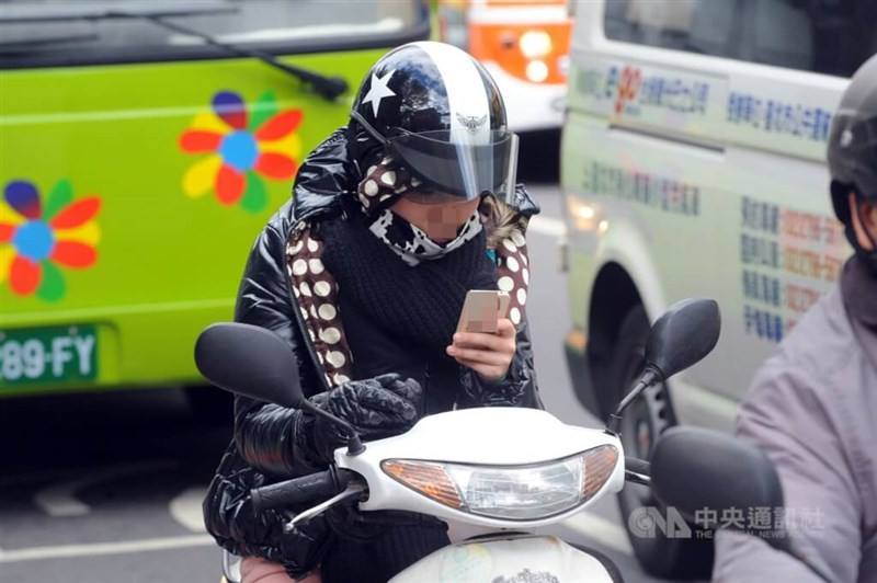 A motorcyclist using their smartphone while stopped at a red light. CNA file photo