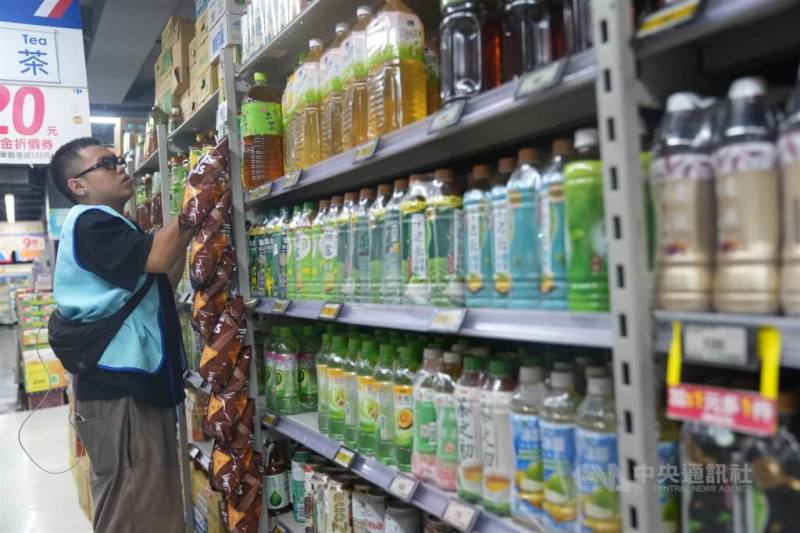 明年元旦起無添加糖飲料品將免徵貨物稅。圖為賣場工作人員為茶飲貨架補貨。（中央社檔案照片）