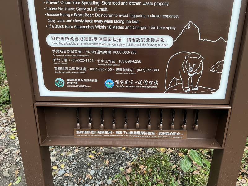 告示牌下方掛置熊鈴，提供山友上攀大小霸前借用，下山後歸還原處即可。（新竹分署提供）