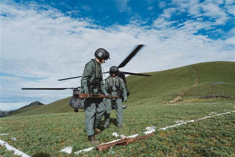 A soldier carries a machine gun dislodged from a U.S. B-24 bomber that crashed into Sancha Mountain in Taitung in 1945. Photo courtesy of Military News Agency