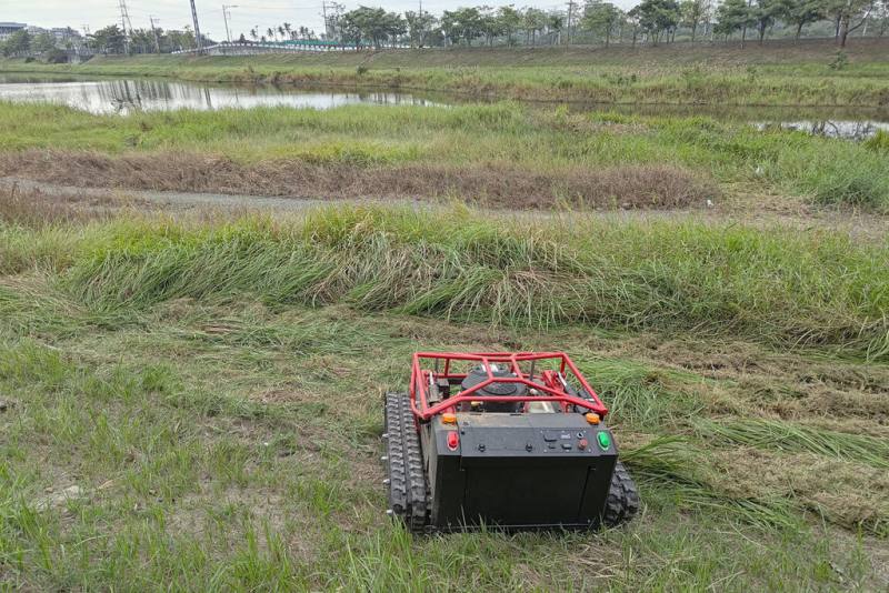 台南市政府水利局邀集工研院及在地廠商研發「智慧割草機器人」，盼提升滯洪池周邊環境維護效率，已在仁德滯洪池完成場域作業實證。（台南市政府提供）