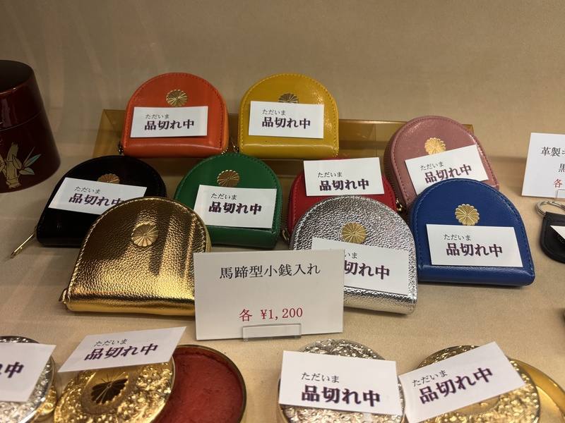 日本皇居內販售的皮革錢包近來因社群媒體的推波助瀾而爆紅。這些錢包以純牛皮手工製作，飾有菊花紋章設計。U字型零錢包顏色有金色、銀色、橘色、粉紅色等，售價1200日圓，價格十分討喜。