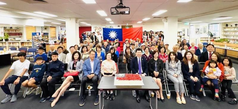 雪梨115年元旦茶會；全體出席僑胞分享元旦國旗蛋糕，以及與中華民國國旗合照。（駐雪梨辦事處提供）