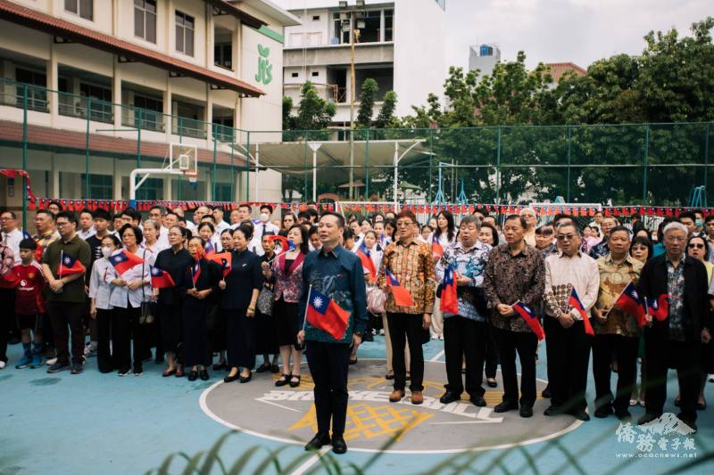 大使洪振榮領唱國歌，全體人員注視國旗冉冉升起