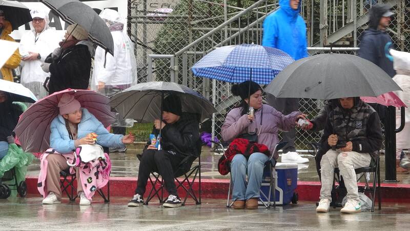 美國新年的重要慶典玫瑰花車遊行在雨中舉行，這是20年來首次雨中遊行，觀眾備妥雨具坐在路邊。