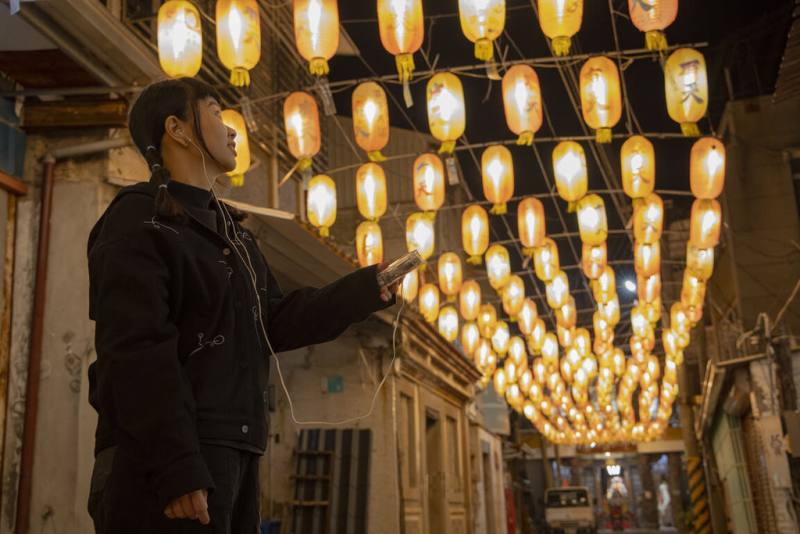 在台南鹽水巷弄街區布展的「月之美術館－2025漫月美行動」，推出音樂散步路徑，遊客可租借舊式隨身聽與錄音帶，在古老巷弄邊走邊聽4首創作樂曲。（台南市文化局提供）