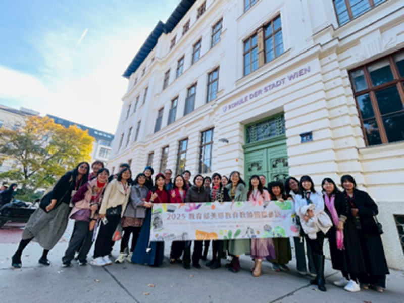 The group in front of the historic OVS Kaisermühlen primary school building after their visit