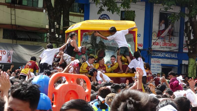 菲律賓天主教規模最大年度宗教盛事「黑拿撒勒人出巡」9日在馬尼拉市登場，民眾不顧危險攀爬神像座駕，用白毛巾擦拭玻璃框，獲得祝福