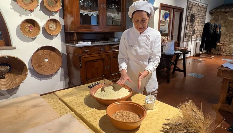 休閒農莊Sa Mandra女主人皮利西（Rita Pirisi）開課傳授以古法捏製手工麵，用背後牆上的木籃將麵印出貝殼刻紋。