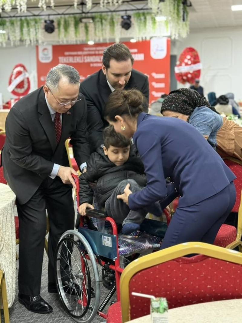 駐土耳其代表黃志揚（左）9日代表台灣，捐贈315台輪椅給土耳其南部阿達那（Adana）的身障兒童使用。圖為黃志揚等人協助身障兒童坐上輪椅。（駐土耳其代表處提供）