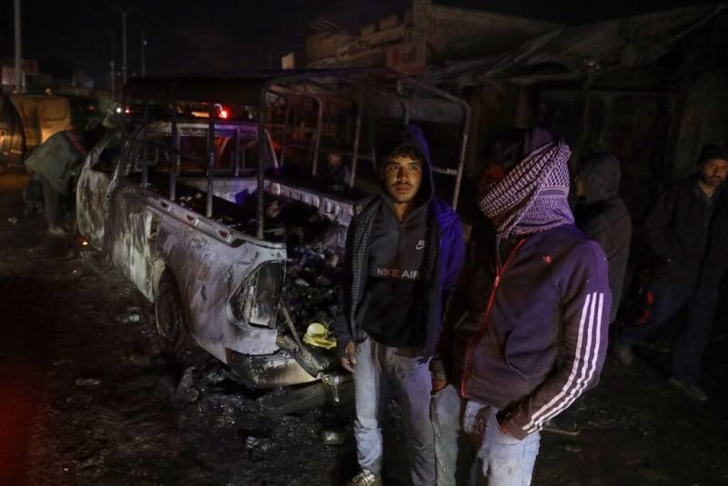 敘利亞政府軍對北部和東部庫德族掌控區推進後，18日宣布與庫德族為首軍事同盟達成停火和整合協議。圖為敘利亞拉卡省民眾站在被焚毀的車輛旁。（美聯社）