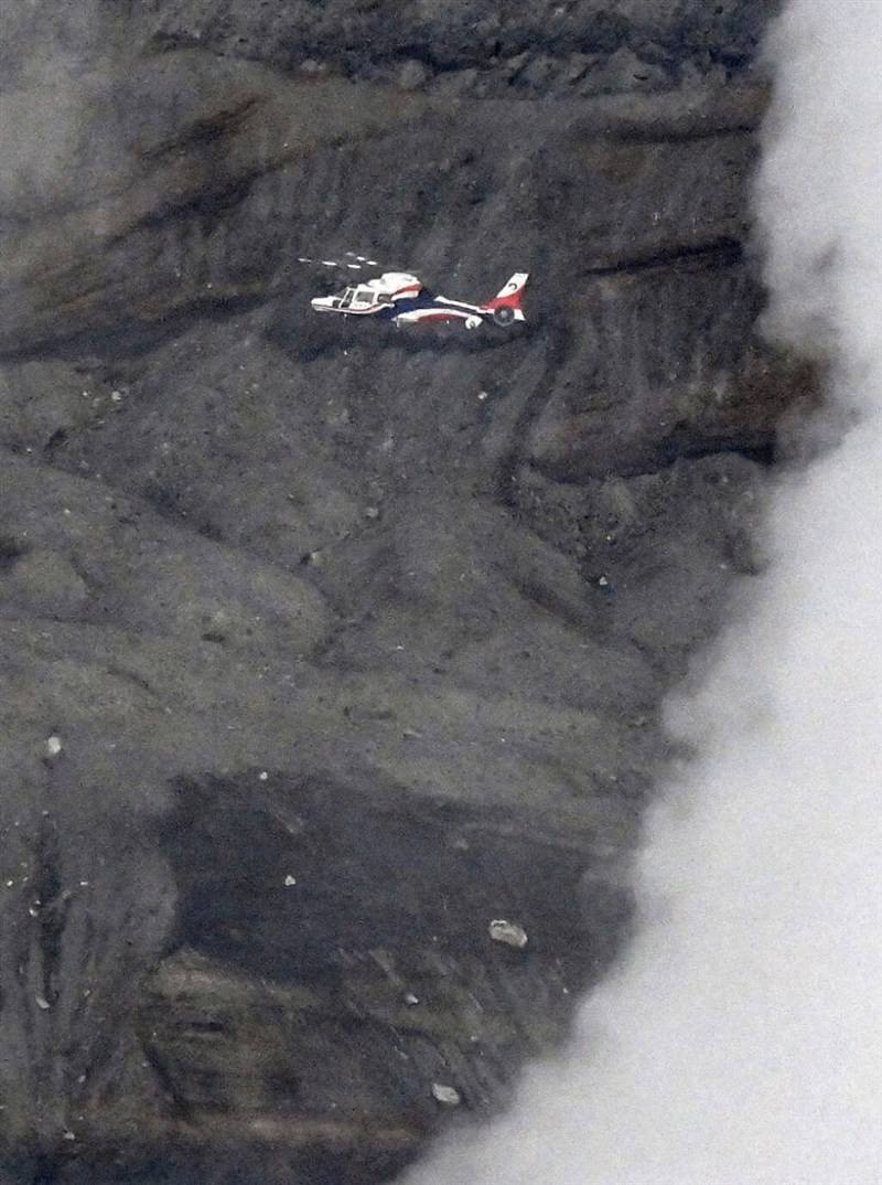A rescue helicopter hovers in the Mount Aso area in search of a missing sightseeing helicopter on Tuesday. Photo: Kyodo News