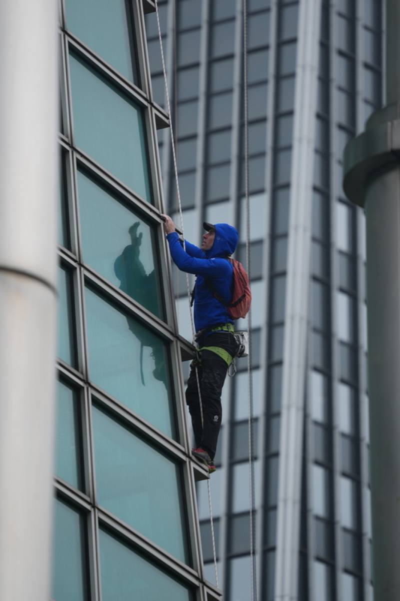 美國自由攀岩好手霍諾德（Alex Honnold）將於台灣時間24日以徒手攀登的方式，挑戰高達508公尺的台北101。圖為21日上午台北市信義區濕冷飄雨，霍諾德在有安全繩及保護裝備下進行試爬