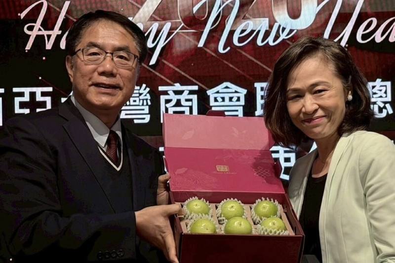 台南市長黃偉哲（左）前往馬來西亞行銷農產品，24日晚間參與當地台商聚會，贈送台南蜜棗給駐馬來西亞台北經濟文化辦事處代表連玉蘋（右）。（市府提供）