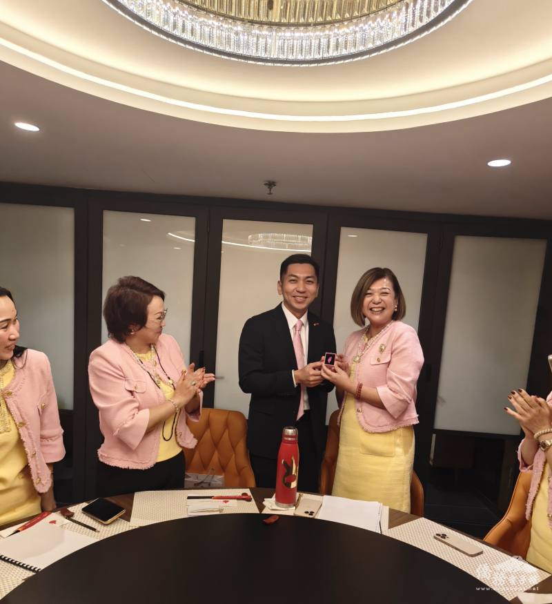 僑務組組長廖建勛代表委員長徐佳青祝賀廖妙溶順利連任，並致贈臺灣造型胸針