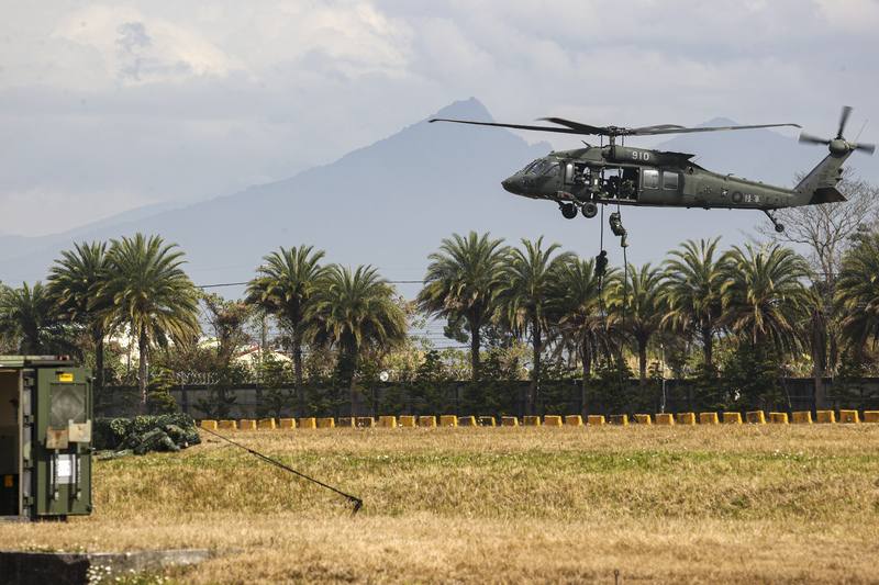 陸軍特戰官兵扮演的共軍半空中自UH-60M繩降，模擬突襲展現精實戰技。中央社記者鄭清元攝