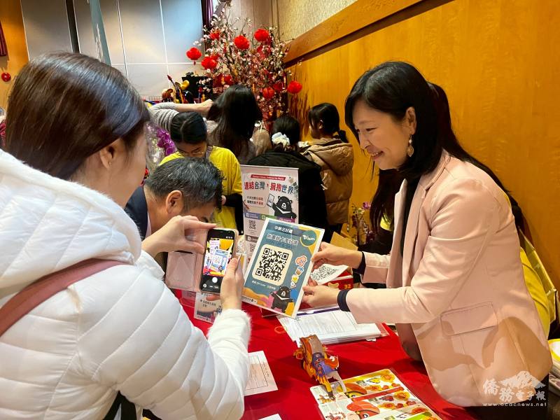 僑務組組長郭淑貞（右）鼓勵僑胞「揪團辦卡享好康」贈送臺灣文創小物